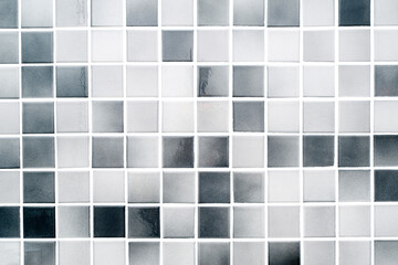 White and grey small ceramic tiles on a bathroom wall, modern clean tile as texture or background