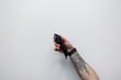 © alones - Man with a tattoo is holding a hair clipper against a white background. Professional male barber. Haircuts, concept