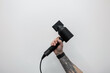 © alones - A professional barber man holding a modern hair dryer in his hand against a white background. Creative master and haircuts