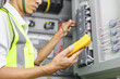© OkayStocker - Electrical engineer or repairman holding digital multimeter to inspecting the electrical system in a factory.