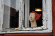 Kobieta z drewna w starym oknie.