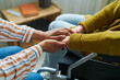 © pressmaster - Close-up of caregiver holding hands with senior woman in wheelchair, she giving her support