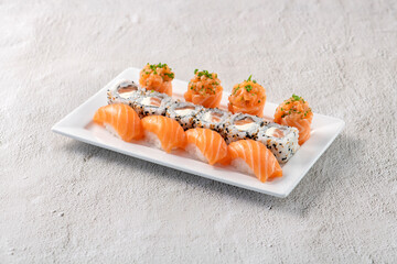 Poster - Fresh made sushi mix. Different kinks of salmon sushi served on white plate. Studio shoot on slated background.