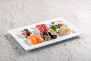 Poster - Sushi mix on white plate. Studio shoot isolated on slate background. Salmon, tuna, octopus and white fish different kinds of sushi. Oriental food on Brazilian way!