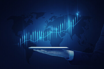 Canvas Print - Global investing and stock market growth concept with digital financial chart raising candlestick on world map background projected from digital tablet on man hand