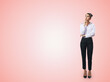 Thinking concept with pensive businesswoman in white shirt and dark trousers standing full length on abstract light pink wall backdrop, with empty place for you text, mock up