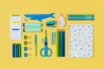 School stationery is arranged neatly on yellow background.  Concept back to school. Workplace organization