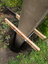 Dig A Deep Hole In The Soil To Pour Mortar On The Fence Posts To Strengthen The Foundation.