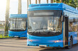 Two blue city passenger buses at the bus terminus waiting for passengers to depart for the route line.