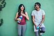 two multi ethnic runner friends leaning on wall and resting after exercising