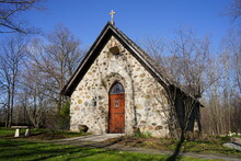 Historical Old Vintage Abandoned Mini Stone Church Stands Enclosed Around A Forest Out In The Countryside