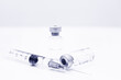 © yjpto - Vial of Drug or Vaccine and 3 ml Plastic Syringe with Needle Isolated on the White Background, blue tone color