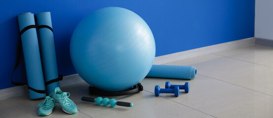 Canvas Print - Set of sports equipment near blue wall in gym