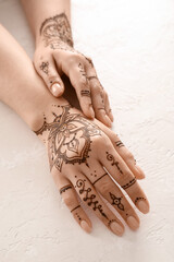Wall Mural - Female hands with beautiful henna tattoo on light background, closeup