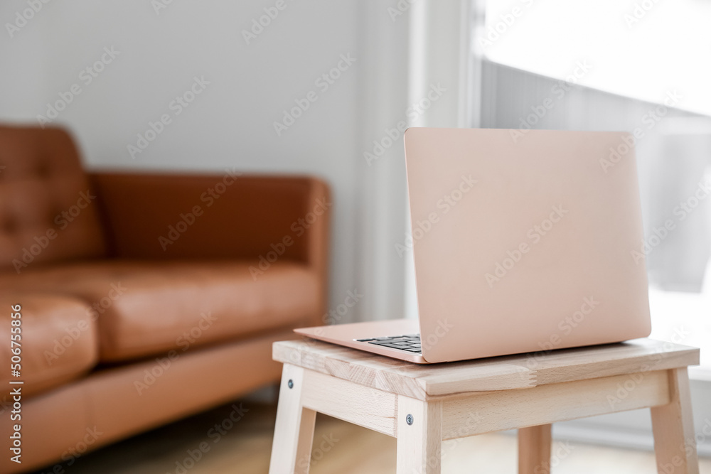 Modern laptop on step stool in living room, closeup