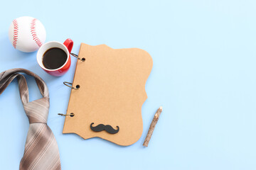 Wall Mural - Father's day concept. bow tie, funny moustache and empty notebook over blue background. top view, flat lay