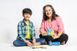 © GAJENDRRA BHATI  - Portrait of happy indian grandmother and grandson playing with colorful Toys, Isolated on white studio background, Grandma Teaching Male Grandchild, Learning Concept.