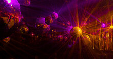 
Purple And Yellow Rays Are Reflected From Mirrored Disco Balls