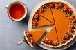 Pumpkin pie, tart made for Thanksgiving day with cup of tea. Grey stone background. Close up. Top view.