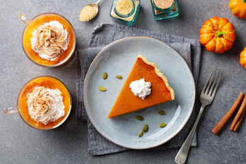 Wall Mural - Pumpkin pie on a plate, pumpkin latte with whipped cream. Grey background. Top view.