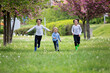 © Tomsickova - Happy children of different age groups, running together in the park, springtime, having fun