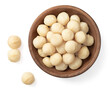 Shelled Macadamia nuts in the wooden bowl, isolated on white background, top view.