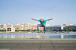 © Retamosa - a man doing an ollie with his skateboard on an asphalt road next to the harbor