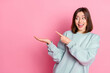 © deagreez - Photo of hooray young lady look hold empty space wear blue hoodie isolated on pink color background