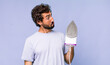 young adult hispanic crazy man with a hand iron. housework concept