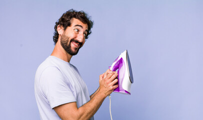 young adult hispanic crazy man with a hand iron. housework concept