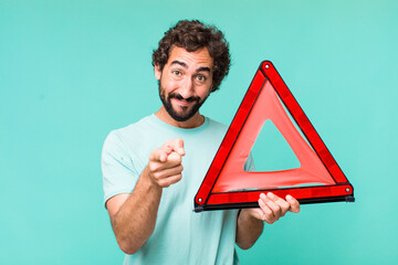 Wall Mural - young adult hispanic crazy man with a car emergency triangle
