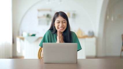 Funny euphoric young asian woman celebrating winning or getting ecommerce shopping offer on computer laptop. Excited happy girl winner looking at notebook celebrating success