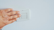 Person Hand To Switching On Or Off Light At Office. Close Up.