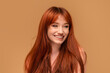 © neonshot - Authentic cheerful ginger girl with beautiful smile, natural freckles, long hair and fringe. Attractive red head woman posing in studio.