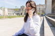 © LIGHTFIELD STUDIOS - cheerful woman talking on mobile phone in european street in vienna.