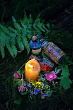 Burning Candle, Magic Witch Bottles, Flowers On Dark Forest Natural Background. Magic Ritual, Witchcraft, Spiritual Practice. Pagan, Wiccan, Slavic Traditions. Esoteric Ritual For Midsummer, Litha