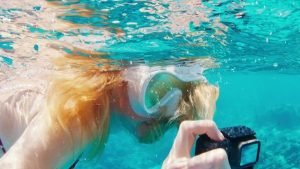 Sticker - Woman with mask swims underwater with action camera and films a content