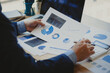 © ArLawKa - Close-up of businessman holding pen pointing to graph graph in document Corporate financial marketing, research, development, planning, management, strategy, analysis, business office concept.