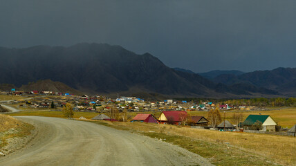 Wall Mural - Russia. The South of Western Siberia, the Altai Mountains. Unpredictable weather over the village in the valley of the Karakol River.