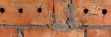 Red Cracked Brick Wall With Holes Background Texture Banner. Panoramic Web Header. Wide Screen Wallpaper
