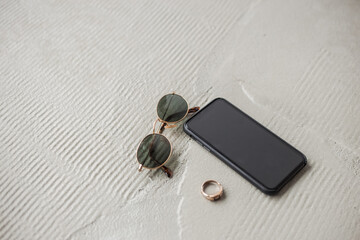 Sticker - Phone and glasses lying on the white concrete floor