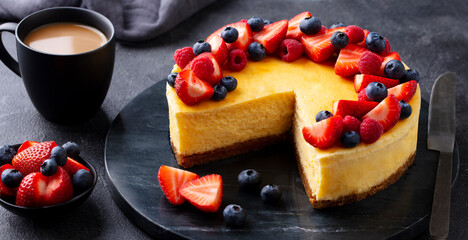 Wall Mural - Cheesecake dessert with fresh berries and cup of coffee. Grey background. Close up.