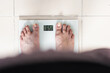 © Mauricio Toro - detailed view of a girl's feet taking her weight on a scale, looking at the exact calculation from the woman's perspective. personal care and diet for a proper functioning of her system.