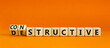 Destructive or constructive symbol. Turned wooden cubes and changed the concept word Destructive to Constructive. Beautiful orange background. Business constructive or destructive concept. Copy space.