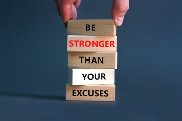 Be stronger symbol. Concept words Be stronger than your excuses on wooden blocks on a beautiful grey table grey background. Businessman hand. Business motivational and be stronger concept.