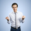 © Who is Danny - Winner and success concept with young happy man with clenched fists isolated on light blue background