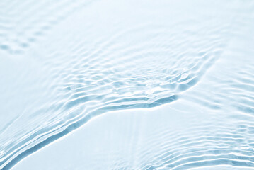 the texture of water on a blue background in bright sunlight.