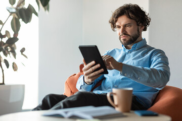 Canvas Print - Portrait of focused man using digital tablet at office