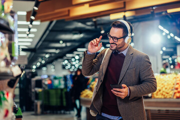 Wall Mural - Handsome man enjoying music on earphones