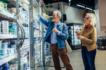 Wall Mural - Senior couple choosing groceries in supermarket